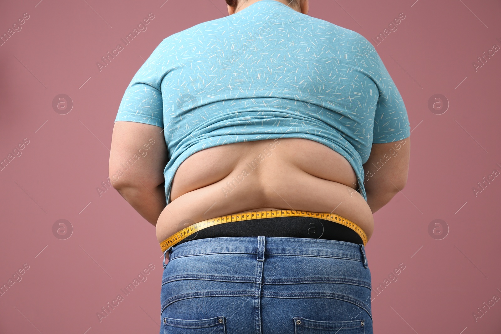 Photo of Overweight woman with measuring tape on color background