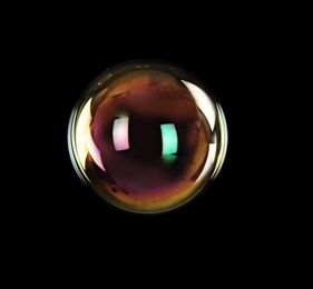 Photo of Beautiful translucent soap bubble on dark background. Space for text