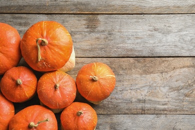 Orange pumpkins on wooden background, flat lay composition with space for text. Autumn holidays