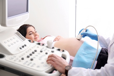 Photo of Young pregnant woman undergoing ultrasound scan in clinic