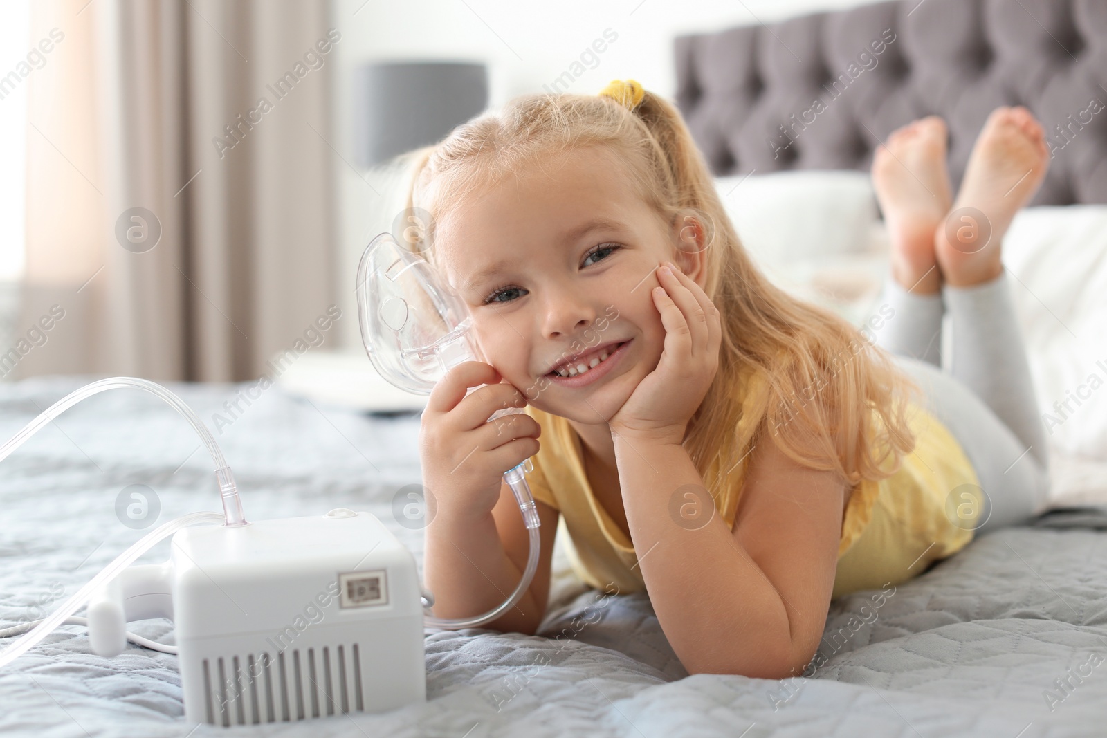 Photo of Little girl with asthma machine in bedroom. Space for text