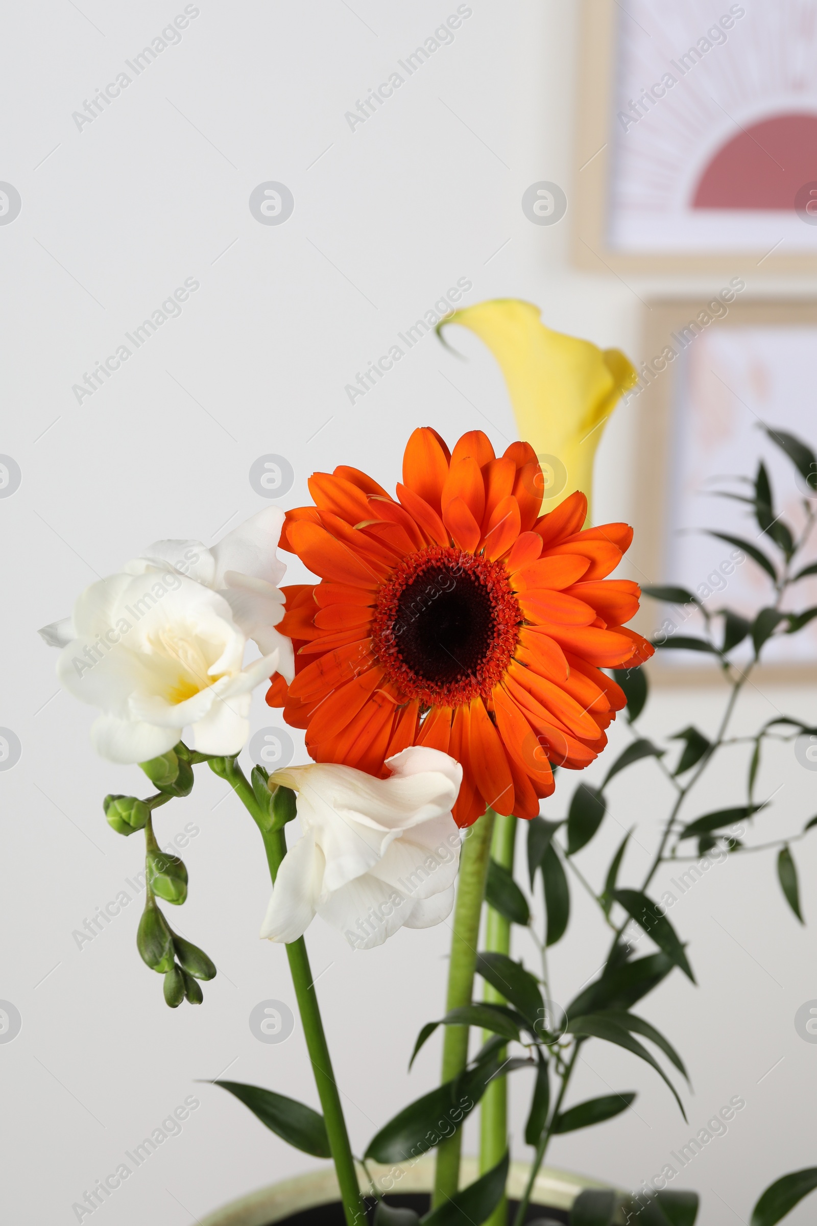 Photo of Stylish ikebana as house decor. Beautiful fresh flowers and branch on blurred background