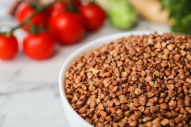 Photo of Uncooked organic buckwheat grains in bowl, closeup