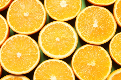 Halves of ripe oranges as background, top view