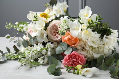 Photo of Bouquet of beautiful flowers on light gray table, closeup