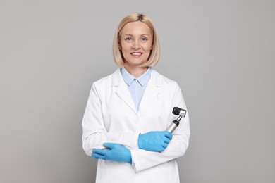 Happy dermatologist with dermatoscope on grey background