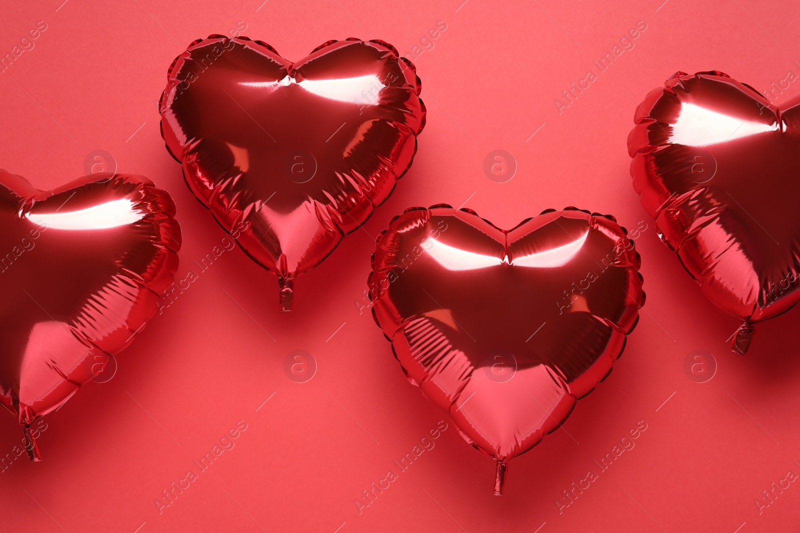 Photo of Heart shaped balloons on red background, flat lay. Valentine's Day celebration