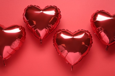 Photo of Heart shaped balloons on red background, flat lay. Valentine's Day celebration