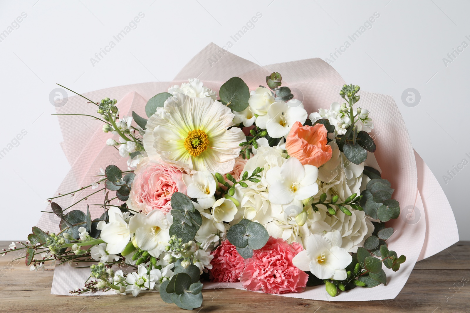 Photo of Bouquet of beautiful flowers on wooden table