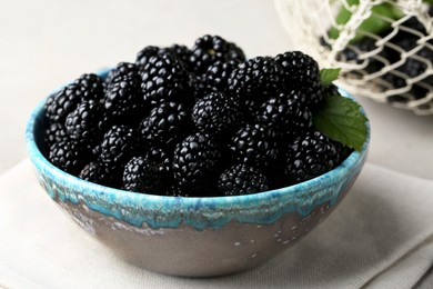 Photo of Tasty ripe blackberries in bowl on table