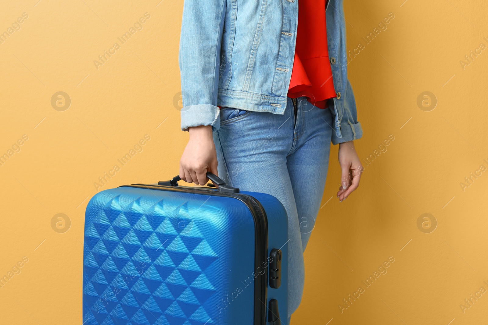 Photo of Young woman with suitcase on color background