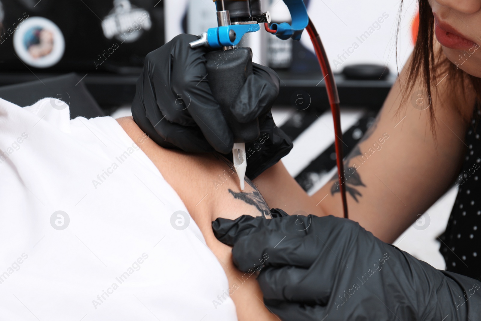 Photo of Professional artist making tattoo in salon, closeup