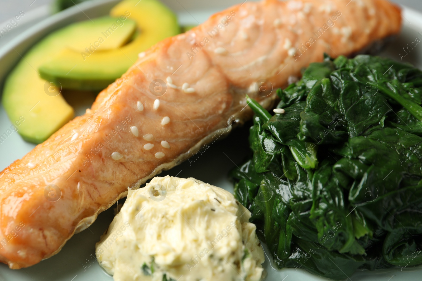 Photo of Tasty salmon with spinach and avocado, closeup