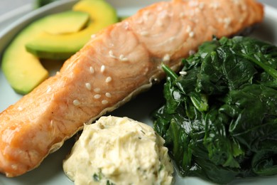 Photo of Tasty salmon with spinach and avocado, closeup