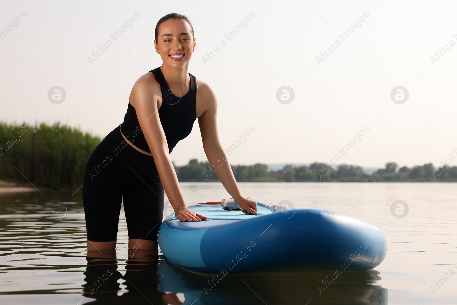 Photo of Woman standing near SUP board in water