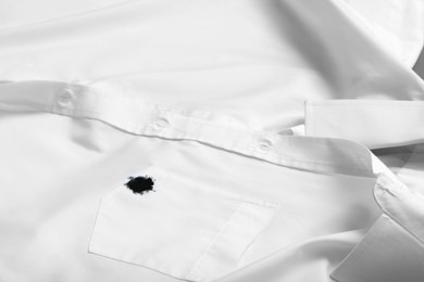 Photo of Stain of black ink on white shirt, closeup. Space for text