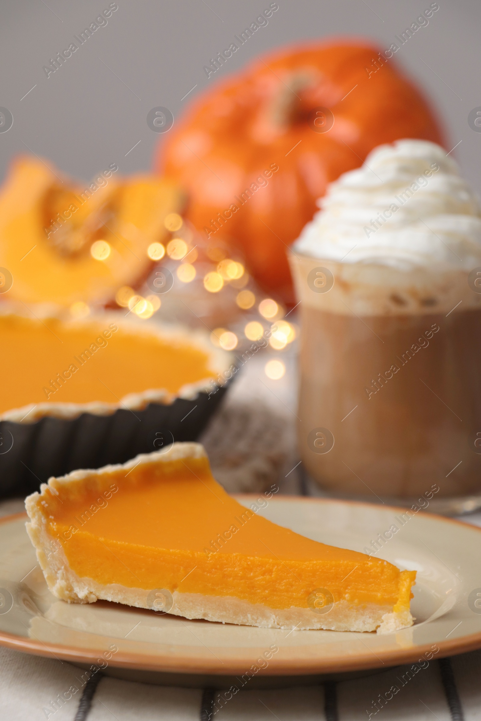 Photo of Fresh homemade pumpkin pie and cup of cocoa with whipped cream on table