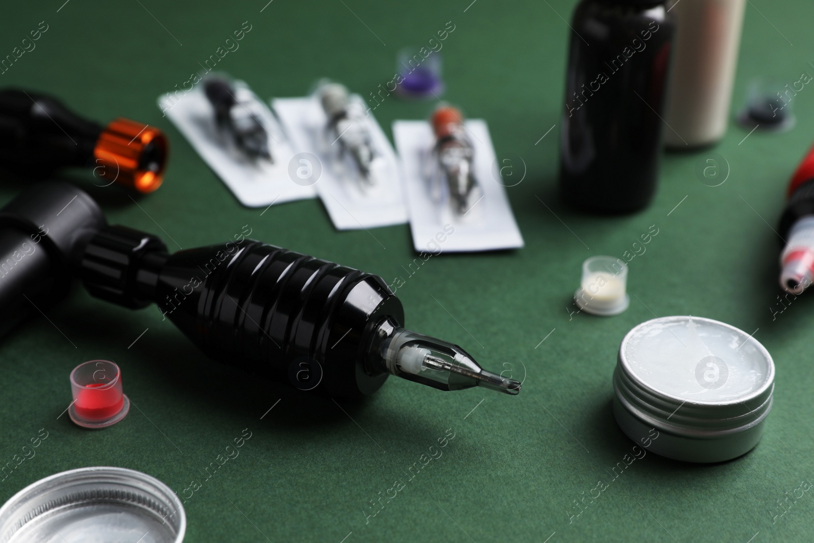 Photo of Tattoo equipment on dark green background, closeup