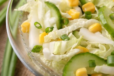 Photo of Tasty salad with Chinese cabbage, corn and cucumber in bowl on table, closeup