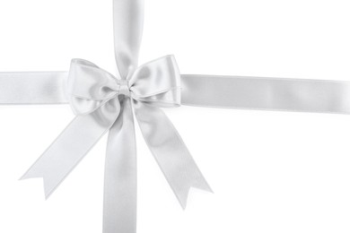 Silver satin ribbons with bow on white background, top view