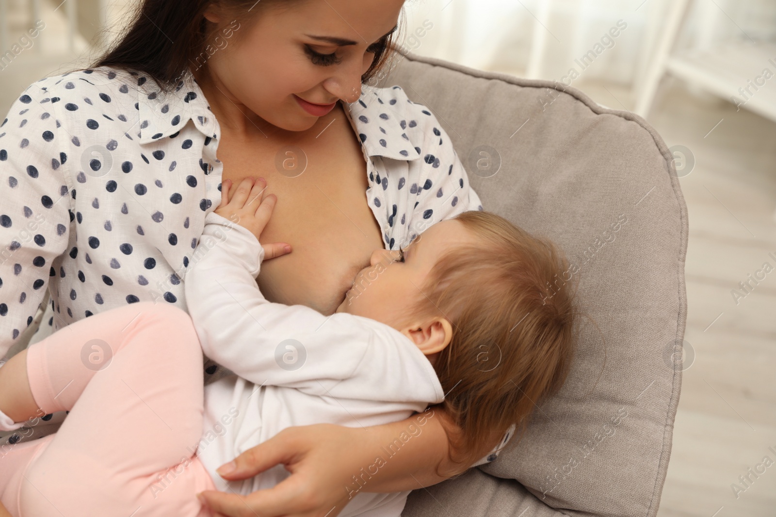 Photo of Woman breastfeeding her little baby at home