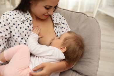 Woman breastfeeding her little baby at home