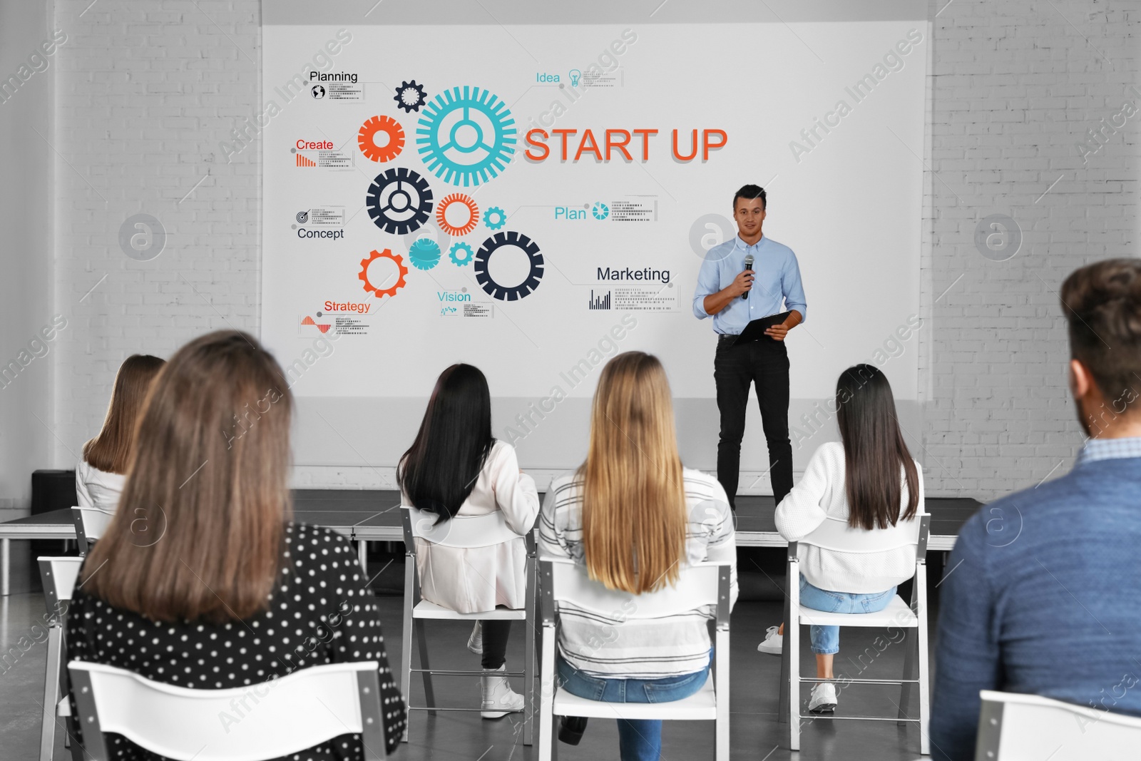 Image of Business trainer giving lecture in conference room with projection screen