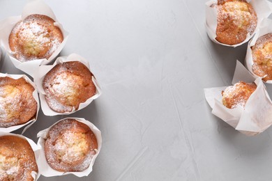 Photo of Delicious muffins on grey table, flat lay. Space for text