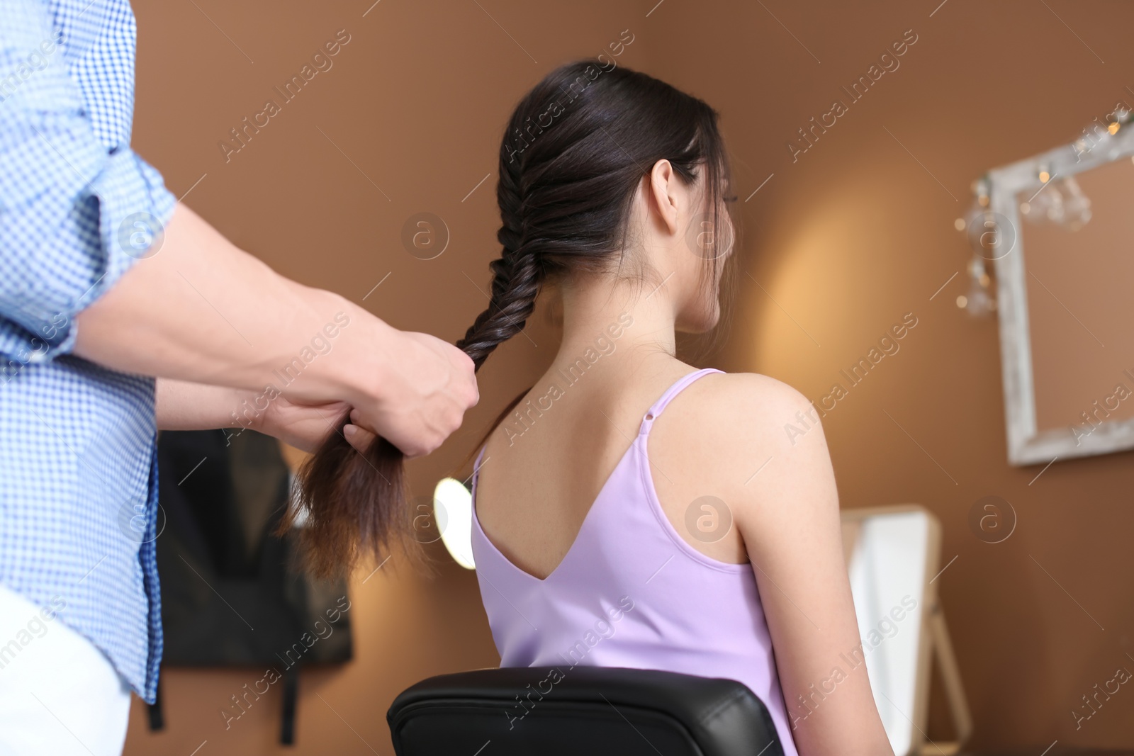 Photo of Professional hairdresser working with client in beauty salon