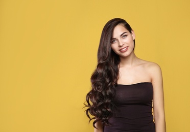 Portrait of beautiful model with gorgeous curly hair on color background