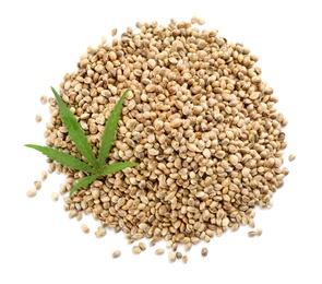 Photo of Pile of hemp seeds and leaf on white background, top view