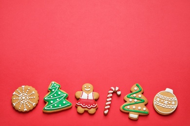 Flat lay composition with tasty homemade Christmas cookies on red background, space for text