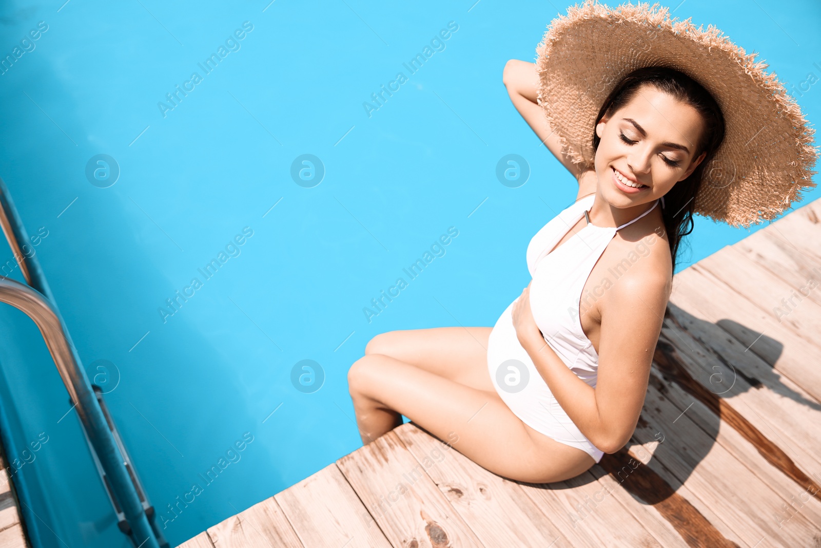 Photo of Beautiful pregnant woman sitting near swimming pool