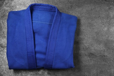 Photo of Blue kimono on gray textured background, top view. Space for text