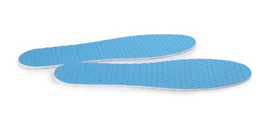 Photo of Pair of light blue insoles on white background