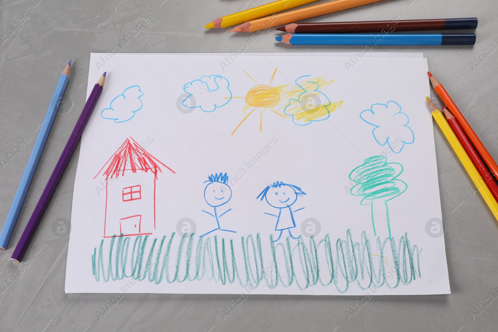 Photo of Cute child`s drawing and colorful pencils on grey textured table, flat lay