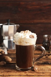 Coffee drink with nutmegs and whipped cream on wooden table