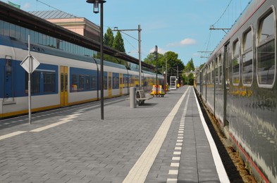 Photo of Modern trains at railway station on sunny day