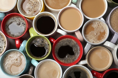 Photo of Many cups with tasty aromatic coffee on table, flat lay