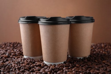Photo of Coffee to go. Paper cups on roasted beans, closeup