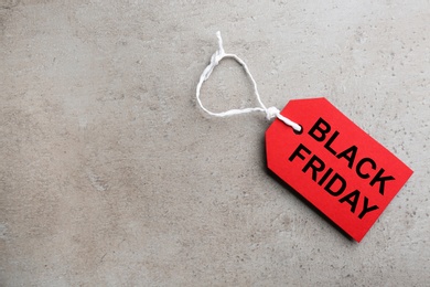 Photo of Top view of blank tag on light grey stone background, space for text. Black Friday concept