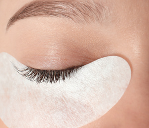 Image of Young woman undergoing eyelash extension procedure, closeup