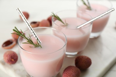 Photo of Lychee cocktail with rosemary on marble board, closeup