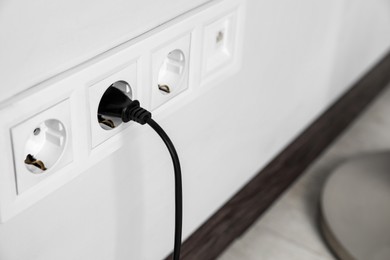 Photo of Power socket and plug on wall indoors, closeup. Space for text