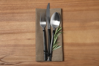 Photo of Cutlery and linen napkin on wooden background, top view