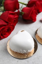 St. Valentine's Day. Delicious heart shaped cake and roses on light table, closeup