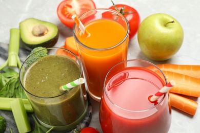Photo of Delicious vegetable juices and fresh ingredients on light grey table