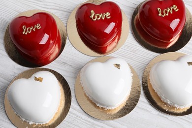 Photo of St. Valentine's Day. Delicious heart shaped cakes on white wooden table, above view