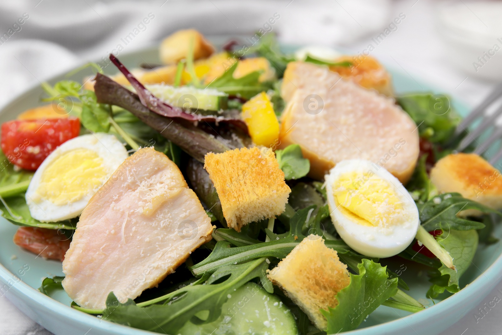 Photo of Delicious salad with croutons, chicken and eggs served on table, closeup