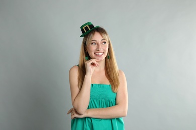 Photo of Happy woman in St Patrick's Day outfit on light grey background